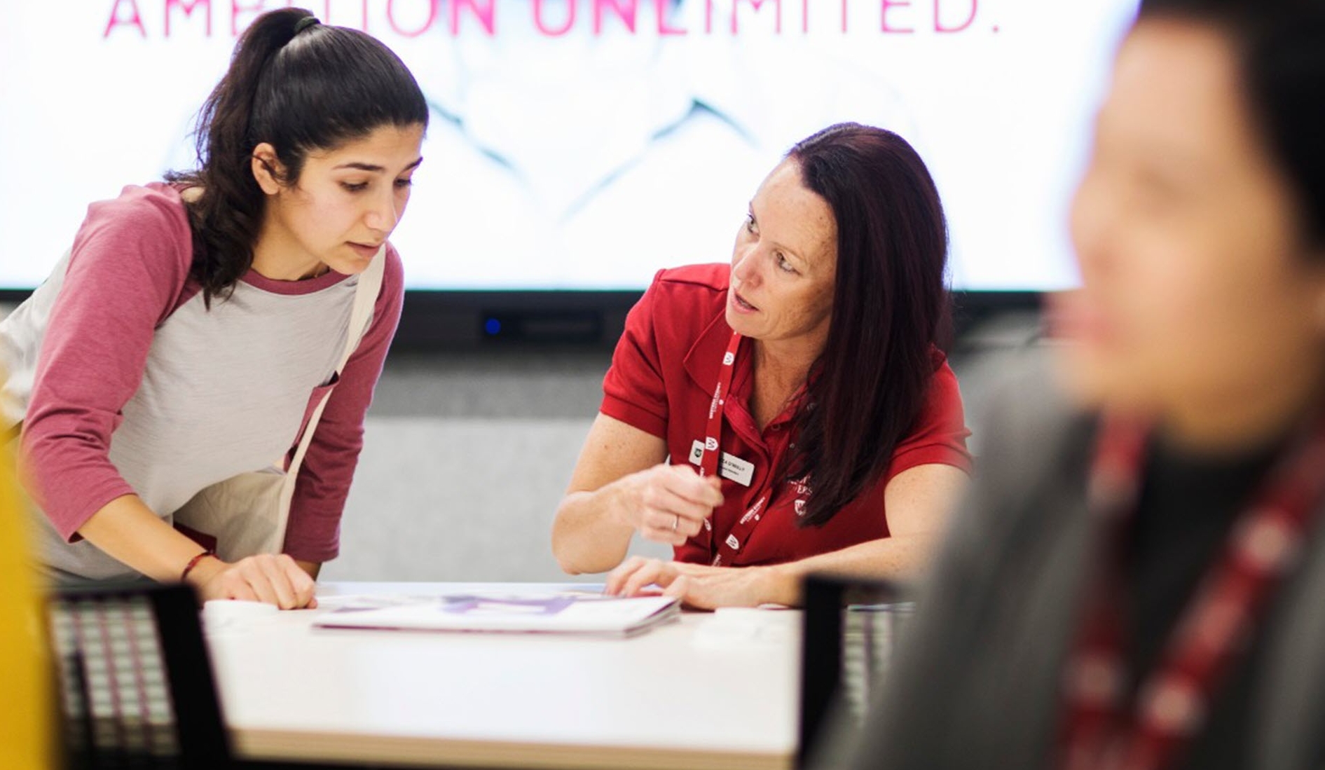 A staff member from student services helping a student